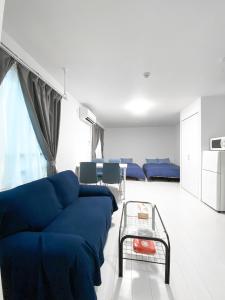 - un salon avec un canapé bleu et une table dans l'établissement FL Residence Takadanobaba, à Tokyo