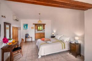 a bedroom with a bed and a table and a desk at Alkifron Hotel in Kala Nera