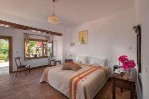 a bedroom with a bed and a table with flowers on it at Alkifron Hotel in Kala Nera