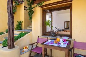 a table and chairs on a balcony with a mirror at Alkifron Hotel in Kala Nera