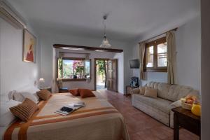 a living room with a large bed and a couch at Alkifron Hotel in Kala Nera