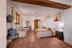 a bedroom with a bed and a couch in a room at Alkifron Hotel in Kala Nera