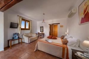 a bedroom with a bed and a living room at Alkifron Hotel in Kala Nera