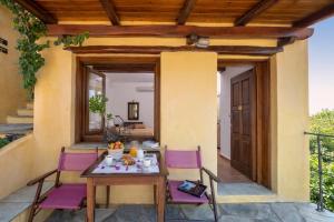 a table and chairs on a patio with a door at Alkifron Hotel in Kala Nera