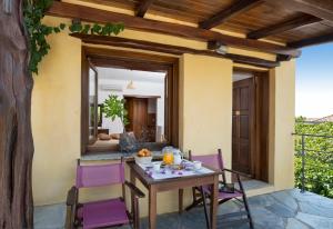 a table and chairs on the patio of a house at Alkifron Hotel in Kala Nera