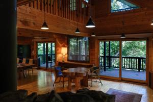 a living room with a table and chairs and windows at Yuki-no Hana Sansou in Takashima