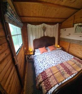 ein Schlafzimmer mit einem Bett in einer Holzhütte in der Unterkunft The Potting Shed in Manuden