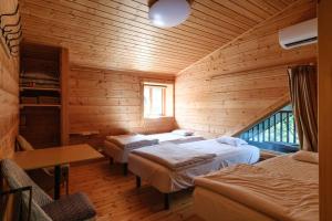 a bedroom with two beds in a wooden cabin at Yuki-no Hana Sansou in Takashima