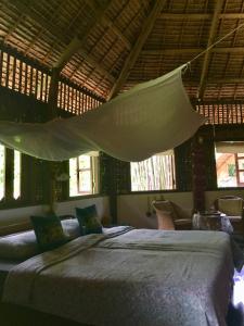 a bedroom with two beds and a mosquito net at Sang Tong Huts in Mae Hong Son