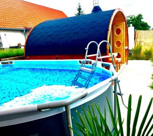 una piscina con un barco en un patio en Penzion Arendel en Líšnice