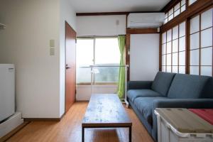 sala de estar con sofá azul y mesa en 2023年4月オープン/東向島駅から徒歩4分/収容人数5/, en Tokio