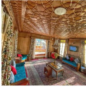 uma sala de estar com um sofá e uma mesa em Nazneen Group Of Houseboats em Srinagar