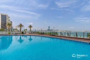 a large swimming pool with a view of the ocean at Dream Inn Apartments - Mina by Azizi in Dubai