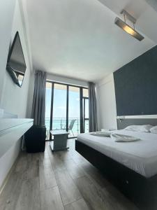 a bedroom with a bed and a view of the ocean at Seaside Inn & Suites in Costinesti +36 photos