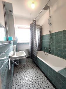 La salle de bains est pourvue d'une baignoire, de toilettes et d'un lavabo. dans l'établissement Fewo Magnolie, à Eschwege