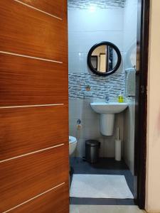 uma casa de banho com um lavatório e uma porta de madeira em Andrew n Sophia's Guest House em Puerto Princesa