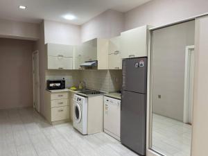 a kitchen with a refrigerator and a washing machine at Park Azure in Baku