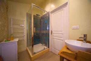 uma casa de banho com uma cabina de duche em vidro e um lavatório. em Cottage with private garden and reverse aircon em La Tour-Blanche