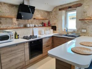 cocina con fregadero y fogones horno superior en Barn cottage en La Tour-Blanche