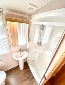 a bathroom with a shower and a sink at Private Lakeside Cabin in St Austell