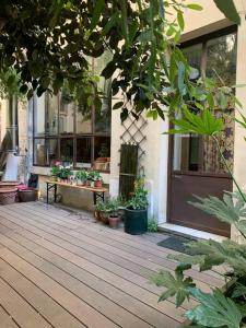 a wooden deck with potted plants in front of a building at Warm and cosy Loft in paris with a private outdoor in Paris