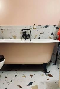 a white bath tub in a bathroom with a toilet at Warm and cosy Loft in paris with a private outdoor in Paris