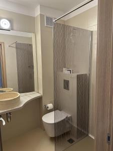 a bathroom with a toilet and a glass shower at Hotel Dorna in Mamaia