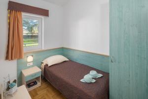 um urso de peluche sentado numa cama num quarto em Apartments Materada Residence em Poreč