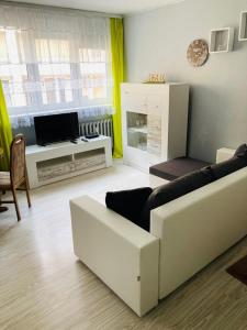 a living room with a couch and a tv at Apartamenty Every Sky Plac Ratuszowy 30 in Jelenia Góra