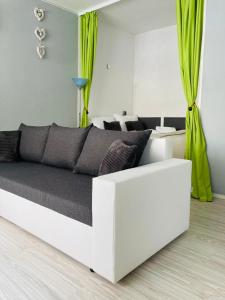 a white bed in a white room with green curtains at Apartamenty Every Sky Plac Ratuszowy 30 in Jelenia Góra