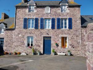 a brick house with blue shutters and a blue door at Chambres d'hôtes Frehel in Fréhel