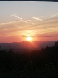 a sunset from the top of a mountain at Glamping Tuscany - Podere Cortesi in Santa Luce