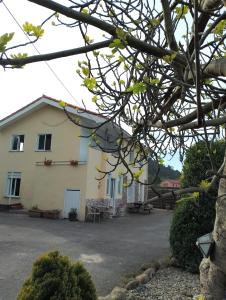 a white house with a driveway in front of it at Pensión Tabaza in Carreno