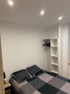 1 dormitorio con cama y estante para libros en Le péageois : Appartement lumineux et calme, en Bourg-de-Péage