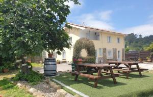 two picnic tables in front of a house at Pensión Tabaza in Carreno