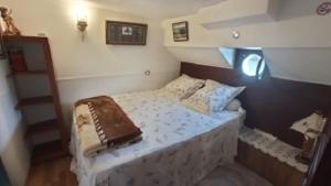 Cama pequeña en habitación con escalera en Bateau Mariance en Ginestas