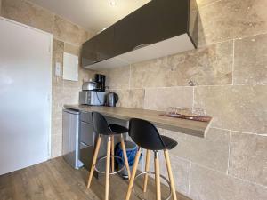 uma cozinha com dois bancos num balcão numa cozinha em Appartement La Baule, 1 pièce, 2 personnes - FR-1-245-107 em La Baule