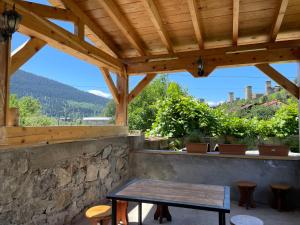 einen Holztisch auf einer Terrasse mit einem Holzdach in der Unterkunft Teona's Guesthouse in Mestia in Mestia