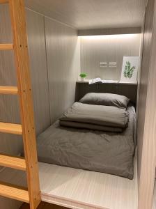 a small bedroom with a bed in a room at 藍貝島潛水背包旅宿一館 Lambay Island Dive Hostel I in Xiaoliuqiu