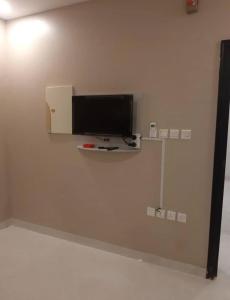 دانة القادسية للوحدات السكنية المفروشة في الرياض: تلفزيون بشاشة مسطحة على جدار