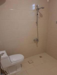 リヤドにあるدانة القادسية للوحدات السكنية المفروشةの白いバスルーム(トイレ、シャワー付)