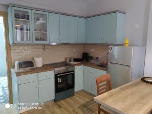 a kitchen with blue cabinets and a white refrigerator at Thalassa Home Comfort in Petra +6 photos