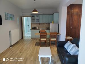 Thalassa Home Comfort في بيترا: غرفة معيشة ومطبخ مع أريكة وطاولة