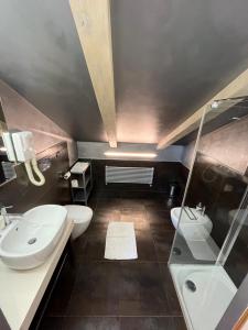 a bathroom with two sinks and two toilets at Hotel Ristorante del Peso in San Michele Mondovì