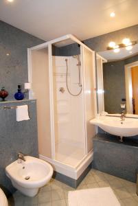 a bathroom with a shower and a toilet and a sink at Hotel Ristorante del Peso in San Michele Mondovì