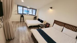 una camera d'albergo con due letti e una finestra di Stay if you wish Homestay a Jiufen