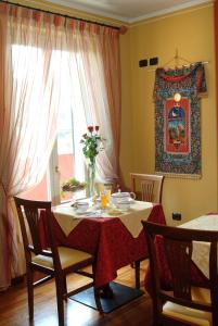 uma mesa de jantar com um vaso de flores sobre ela em Hotel Ristorante del Peso em San Michele Mondovì mais 10 fotografias