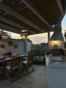 patio ze stołem i krzesłami oraz kuchnią w obiekcie My Happy Place w mieście Calasetta
