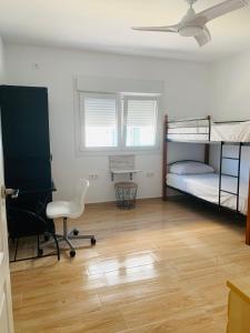 a room with two bunk beds and a desk at Apartamento Delfin - Punta Umbria in Punta Umbría