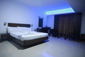 a bedroom with a bed and a blue light at Hotel Finch in Erāttupetta